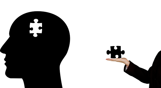 silouetet of a head with a jig-saw piece missing and a hand holding the missing piece